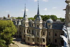 Widok pałacu Izraela Poznańskiego od strony zadrzewionego ogrodu spacerowego.