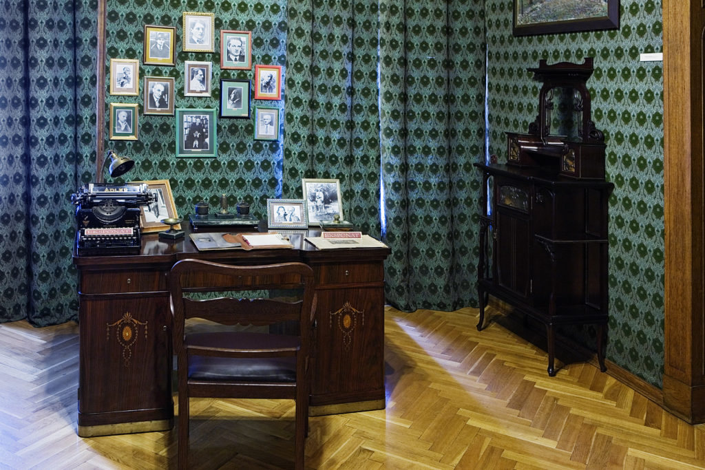 Widok na gabinet upamiętniający postać Juliana Tuwima, z pamiątkami po poecie, rekopisami, fotografiami, wydaniami dzieł oraz gramofonem szafkowym z początku dwudziestego wieku.
