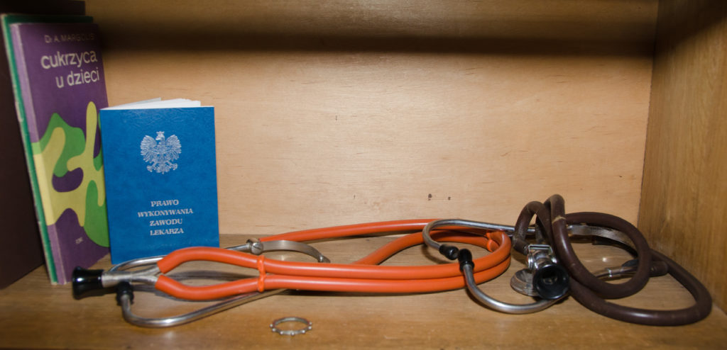 Zbliżenie na pamiątki Marka Edelmana, słuchawki lekarskie (stetoskop) z gumowymi przewodami i metalowym uchwytem.