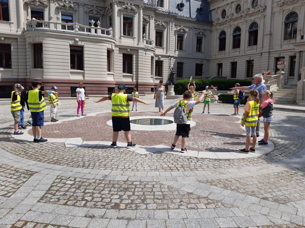 Edukator z grupą dzieci w ogrodzie Pałacu Rodziny Poznańskich
