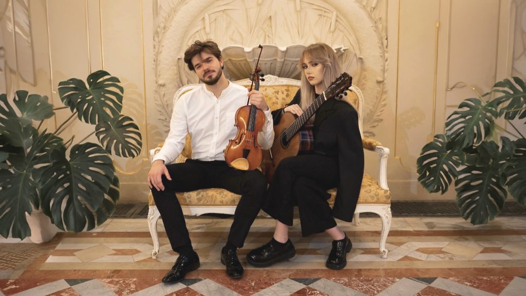 dwójka wykonawców trzyma instrumenty
