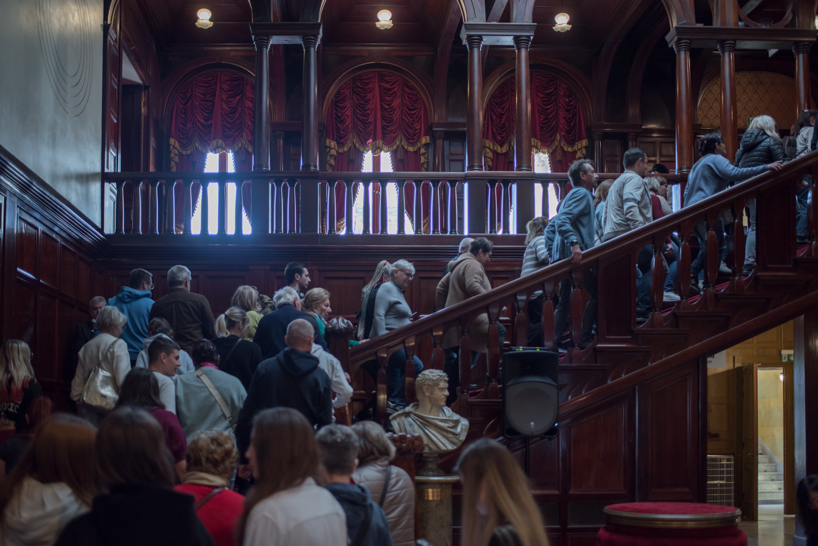 Grupa ludzi wchodząca po schodach w holu głównym Pałacu Rodziny Poznańskich