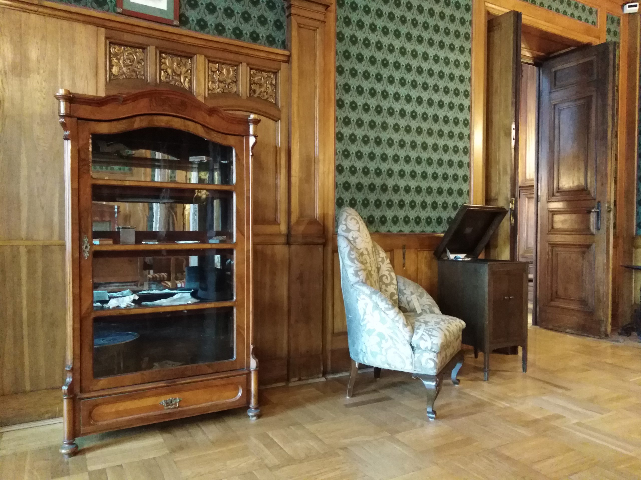 Widok na przeszklony mebel z kolekcją pamiątek osobistych Władysława Stanisława Reymonta.